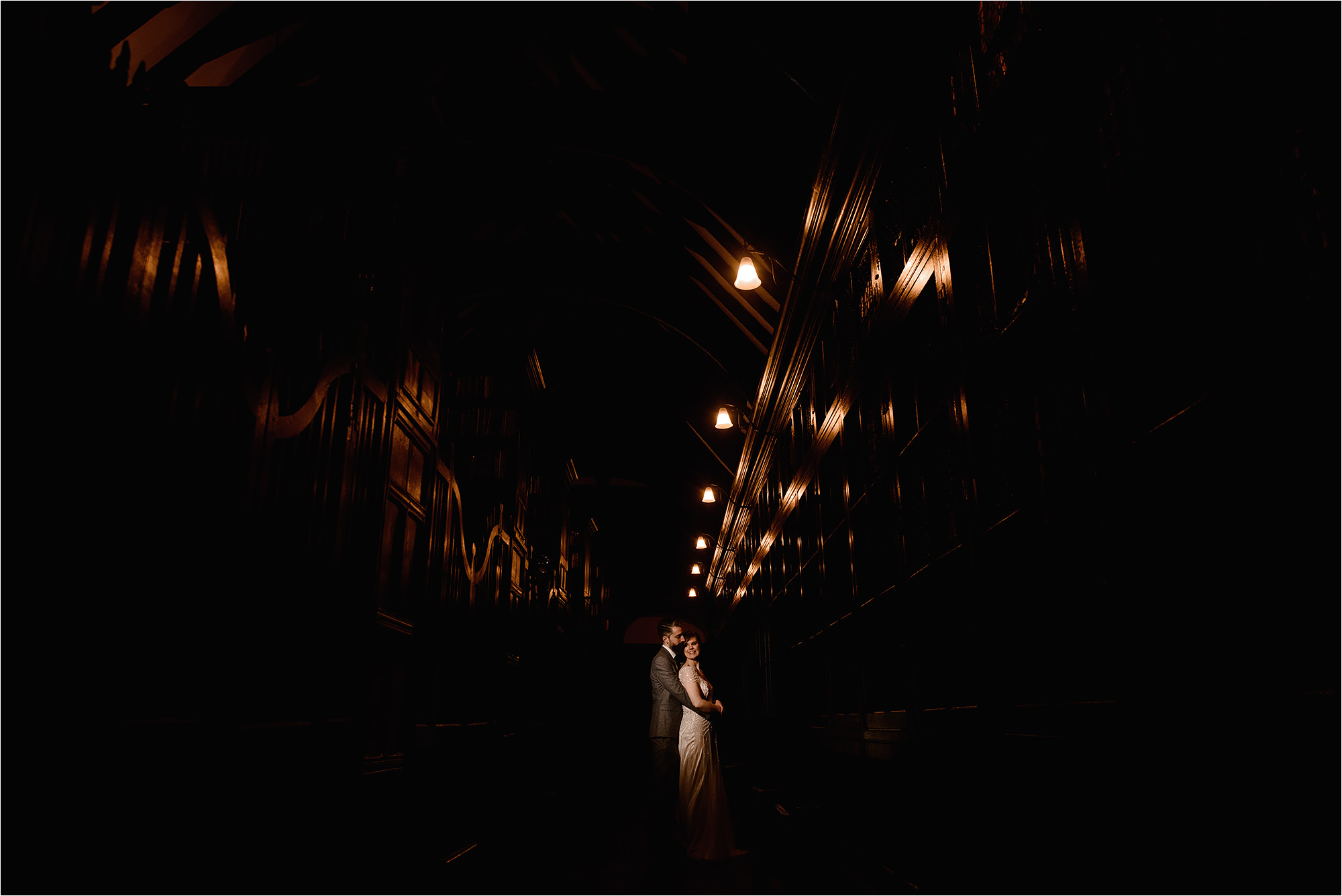 Bride and Groom lit with a video light in the amazing Chetham's Library
