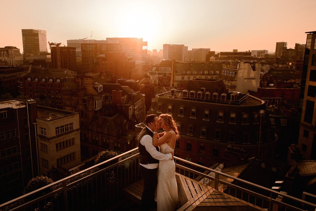 Bride and Groom kissing in front of the Manchester skyline