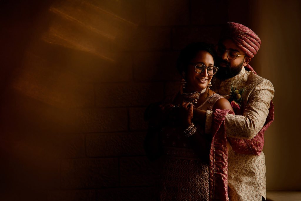 Bride and Groom close together by a window