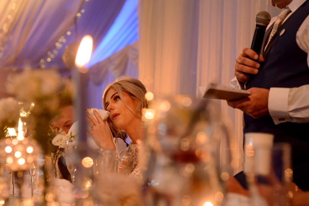 Bride dabbing her eyes as she gets emotional at the speeches