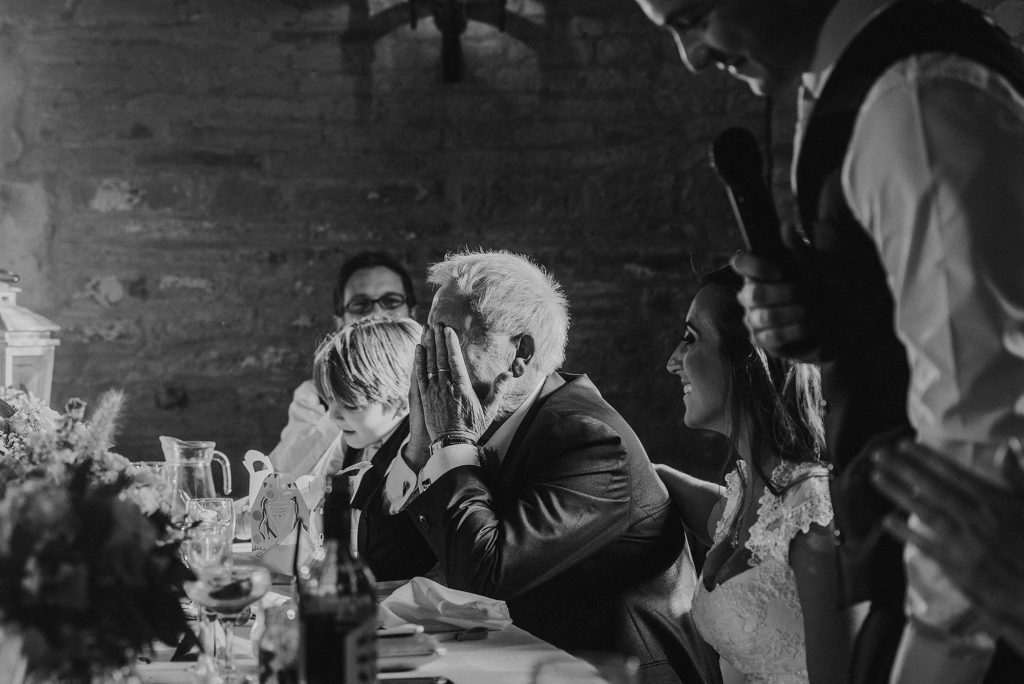 Groom's dad getting emotional with head in his hands as the Groom delivers his speech