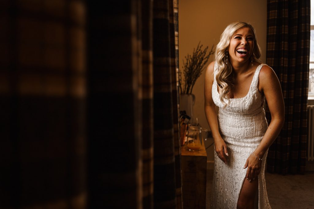 Bride laughing near a window