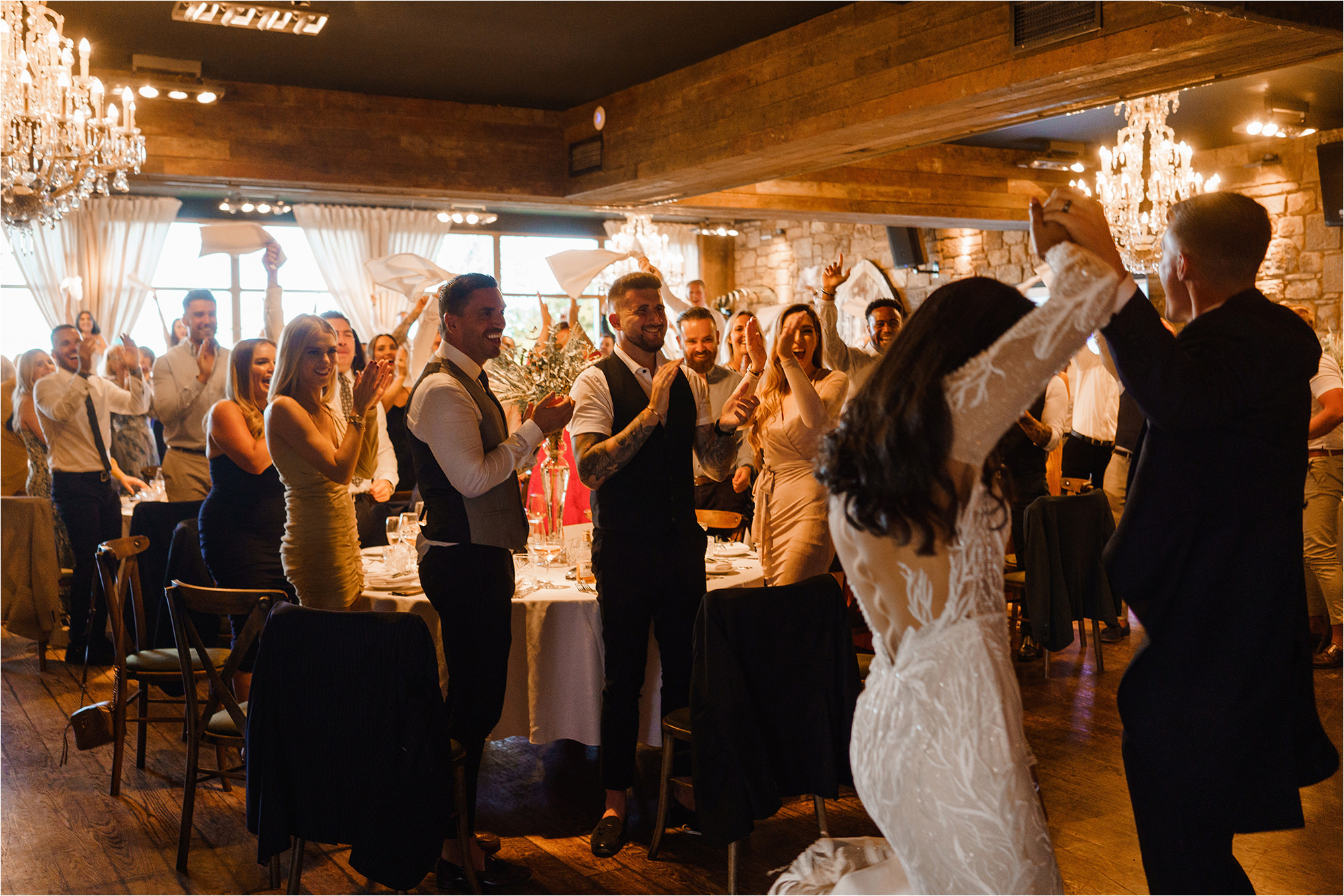 Wedding Guests clapping as the Bride and Groom walk into the room