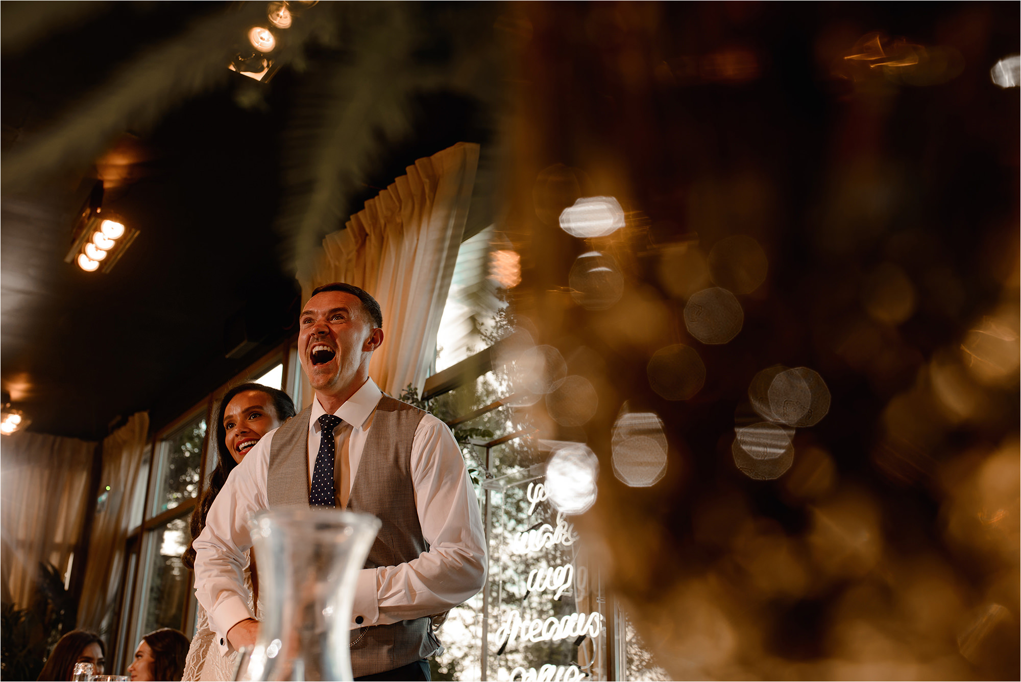 Bride and Groom watching a video speech and laughing