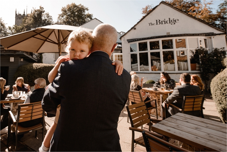 Little girl looking over the shoulder of a Wedding Guest