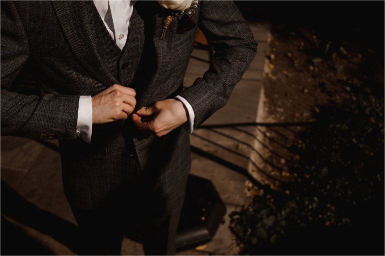 Groom fastening his jacket