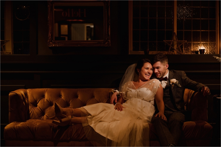 Bride and Groom sat together on a sofa for portraits