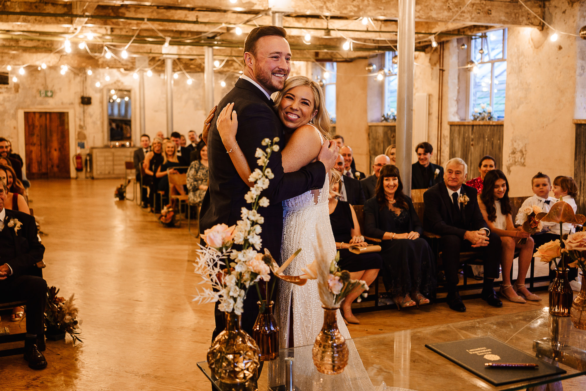 Bride and Groom hugging at the end of the aisle