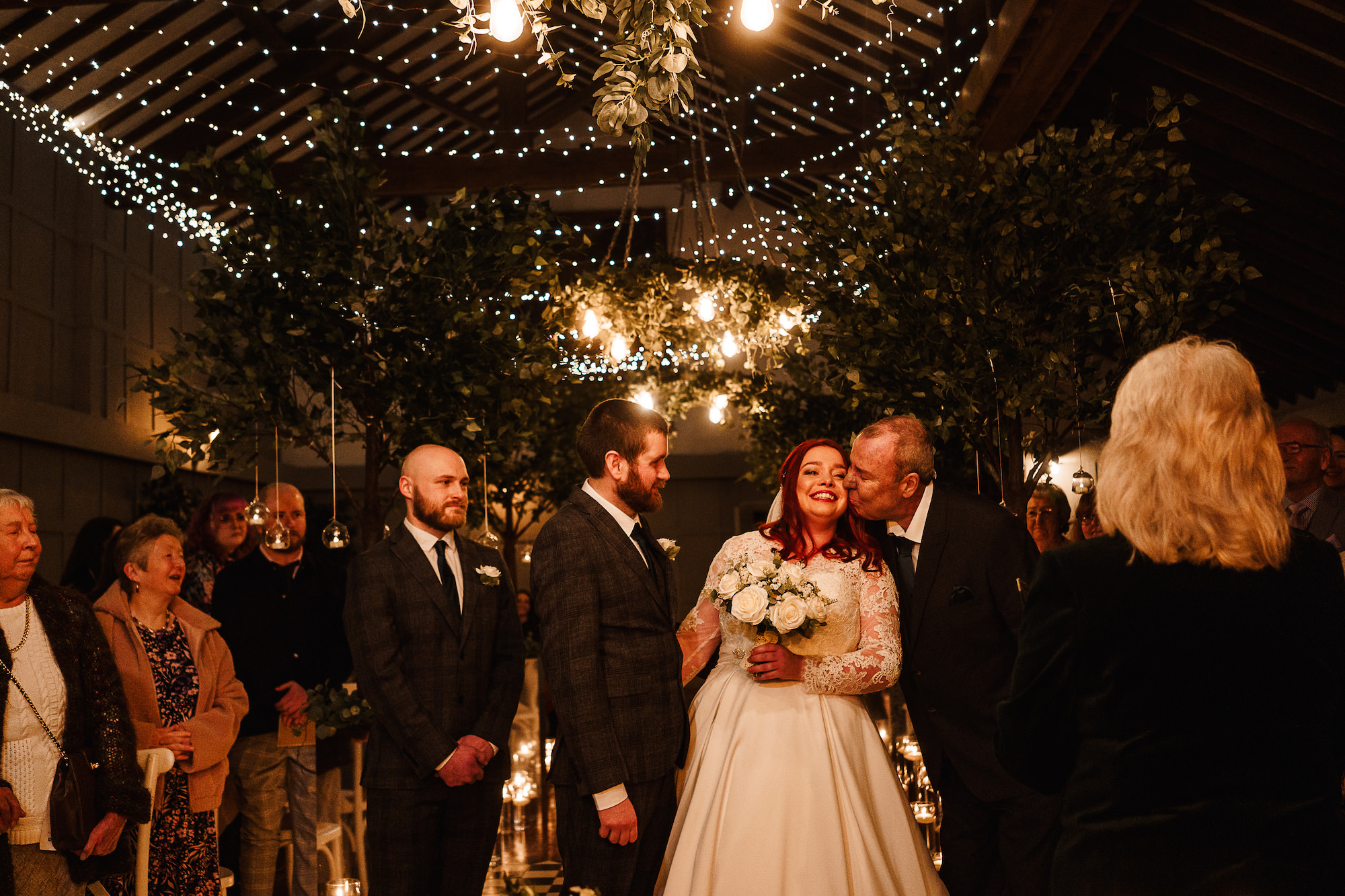 Father of the Bride kissing Brideat the end of the aisle