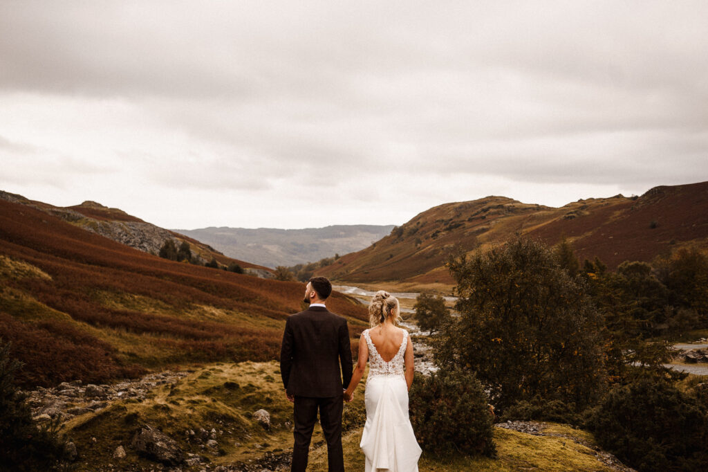 Bride and Groom looking out over a view of mountains in the Lake District